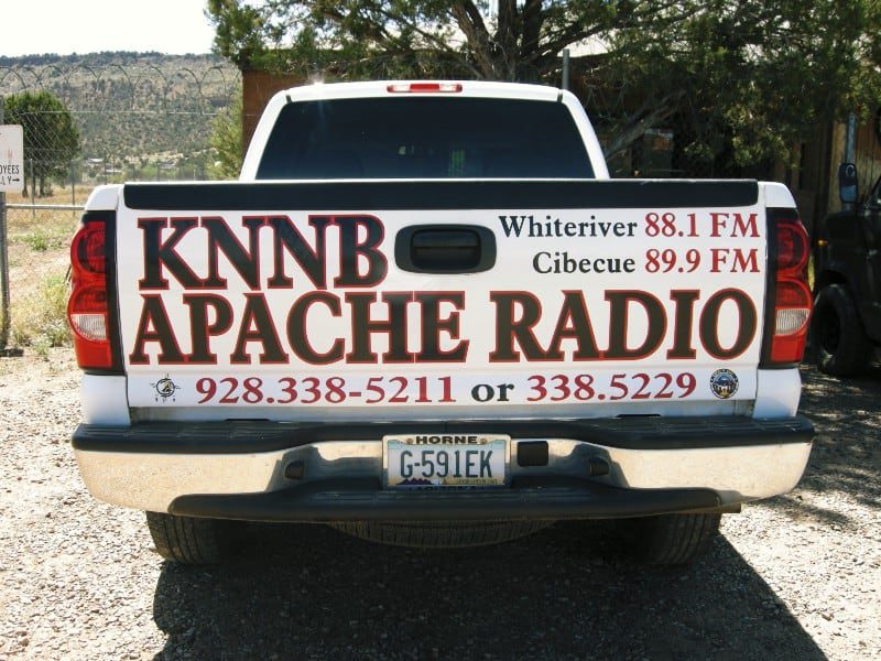 A white pickup truck with KNNB Apache Radio written on the back