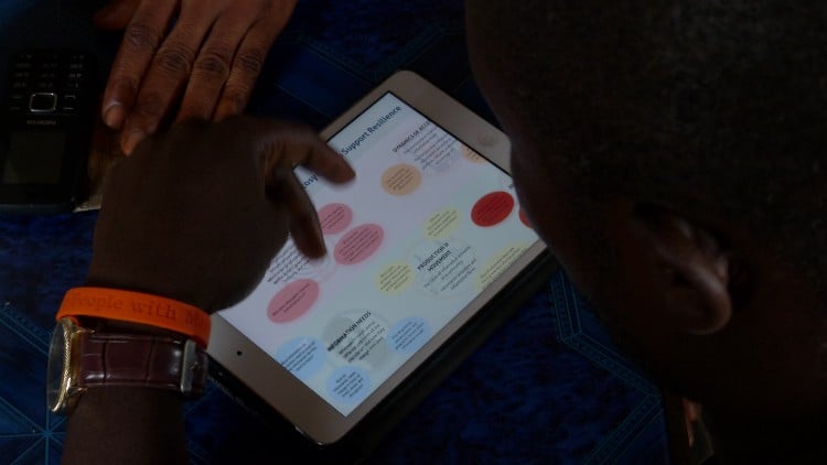 A man looks at the information ecosystem infographic on a tablet
