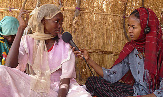 Journalist Houda Malloum (right) interviews a woman in a refugee camp in Chad for a weekly radio show she produced — “She Speaks, She Listens.” — that focused on violence against women and girls.