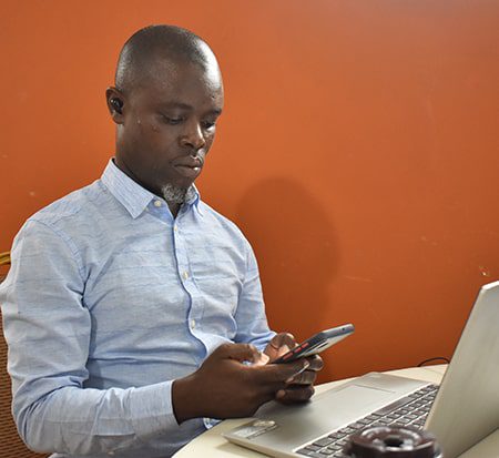 A man sits working on a laptop computer