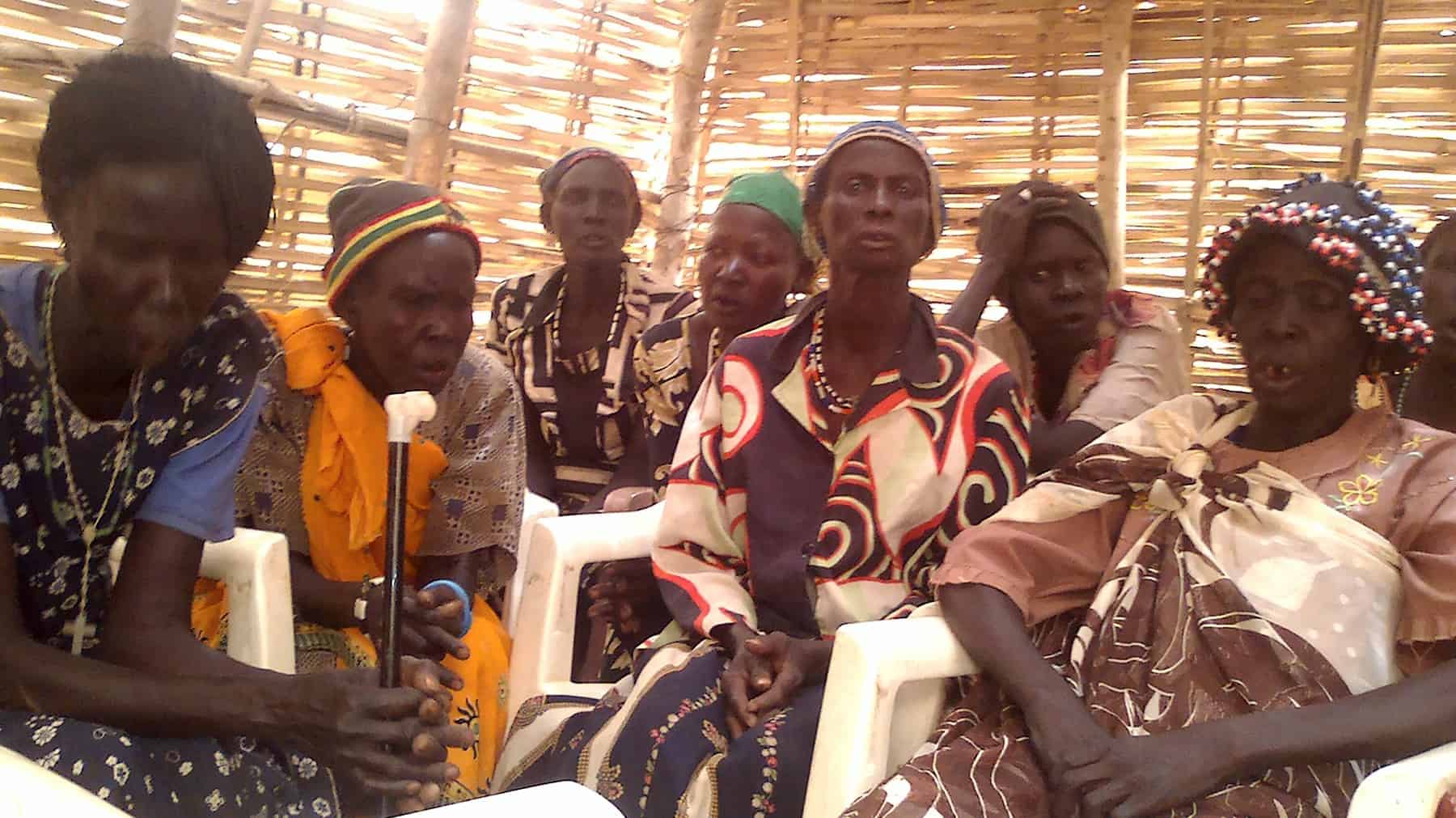 A group of South Sudanese women sit in a structure