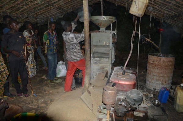 A man pours rice into the milling equipment