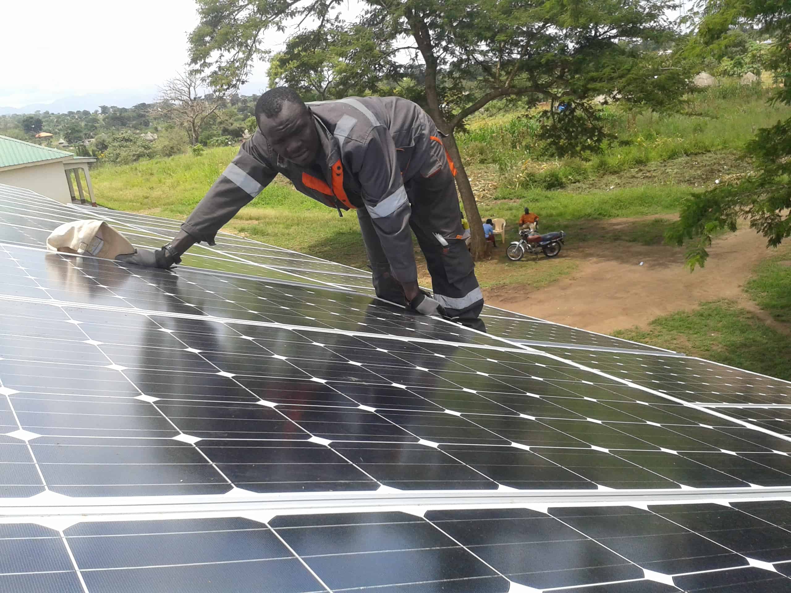 A man wipes off dust from a solar panel