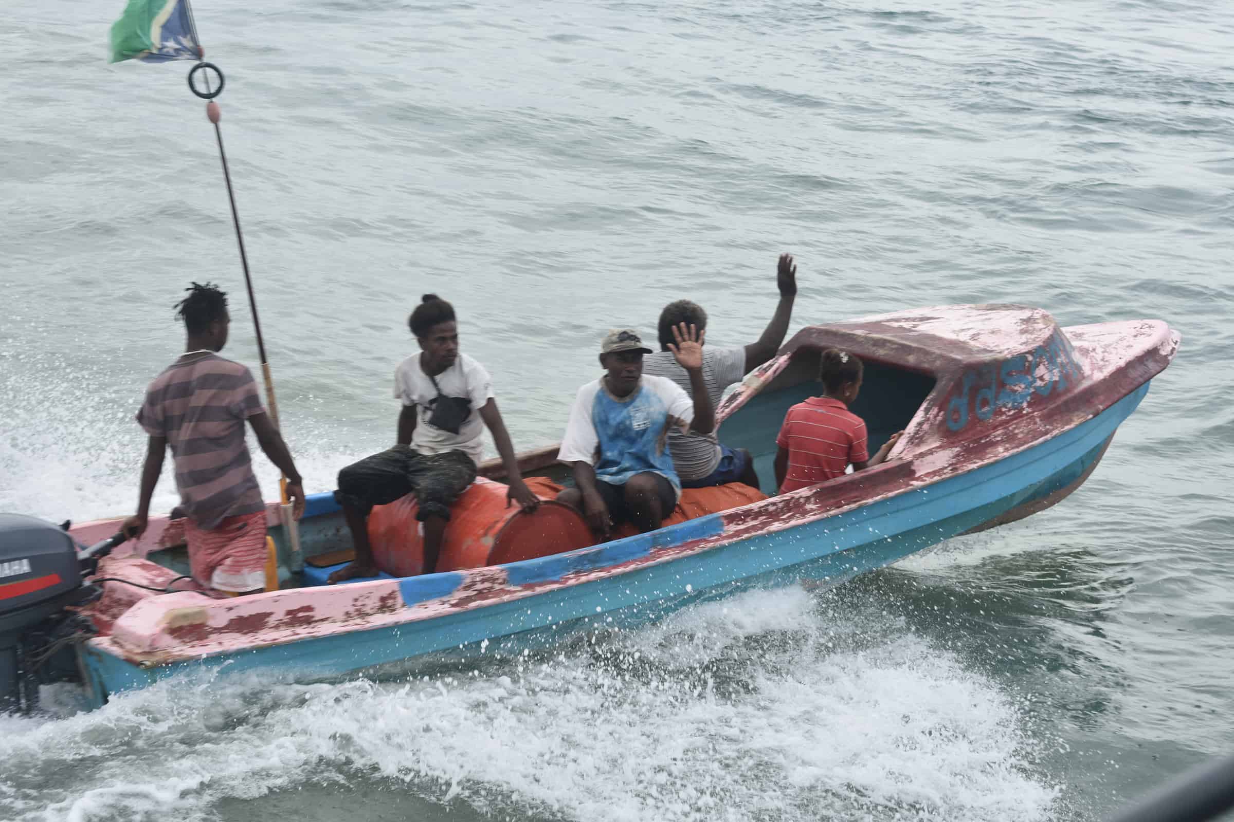 A group of people ride in a boat on a river