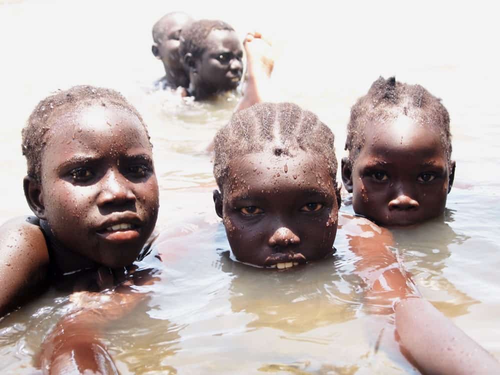 Five girls swim in a river