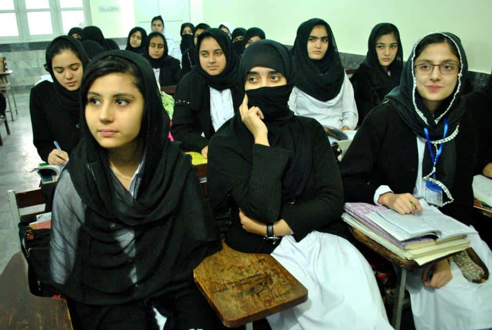 A group of girls sit in a classroom