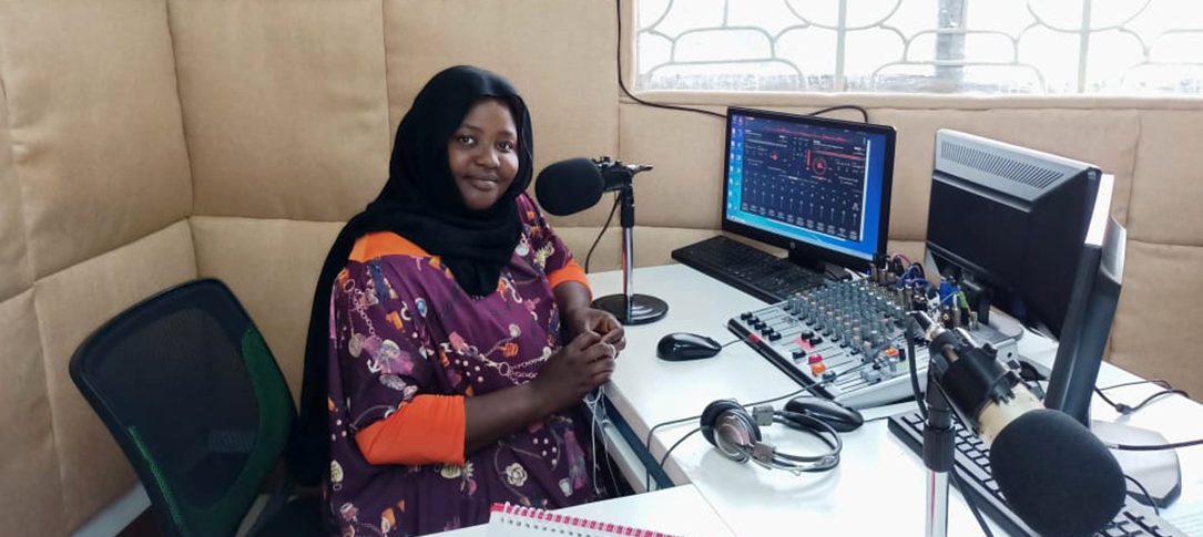 A woman sits in a radio studio
