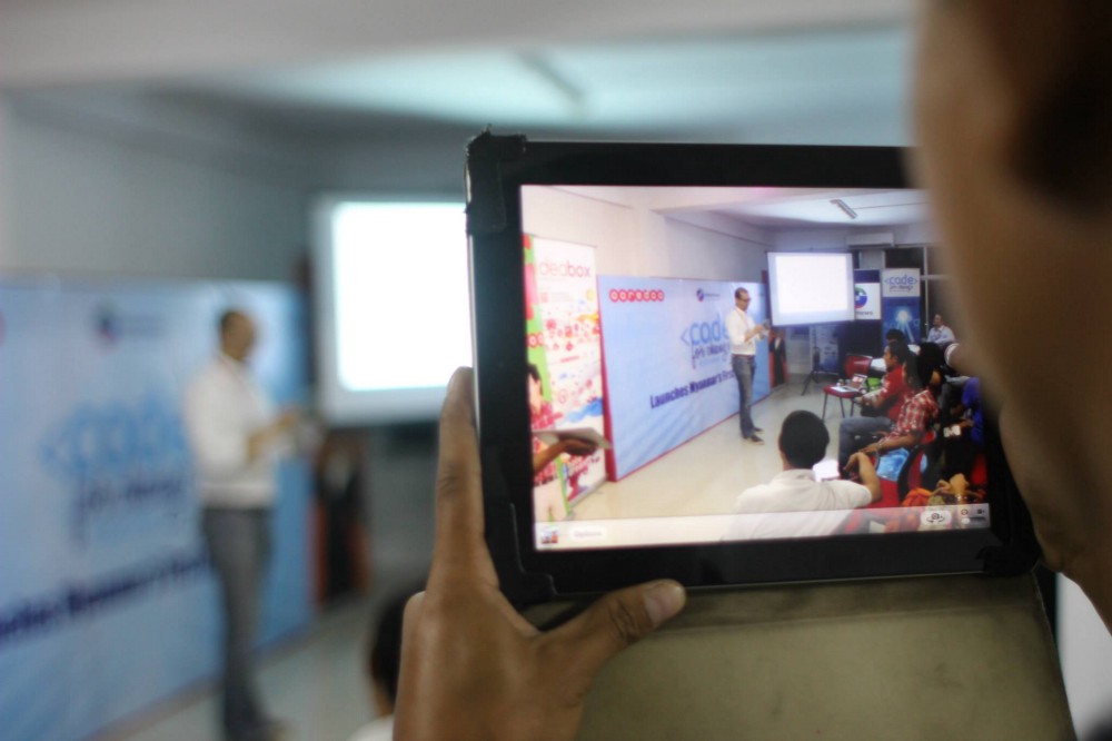 A man videotapes a workshop using his tablet