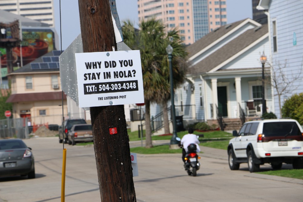 A sign on a telephone pole has the number for the Listening Post