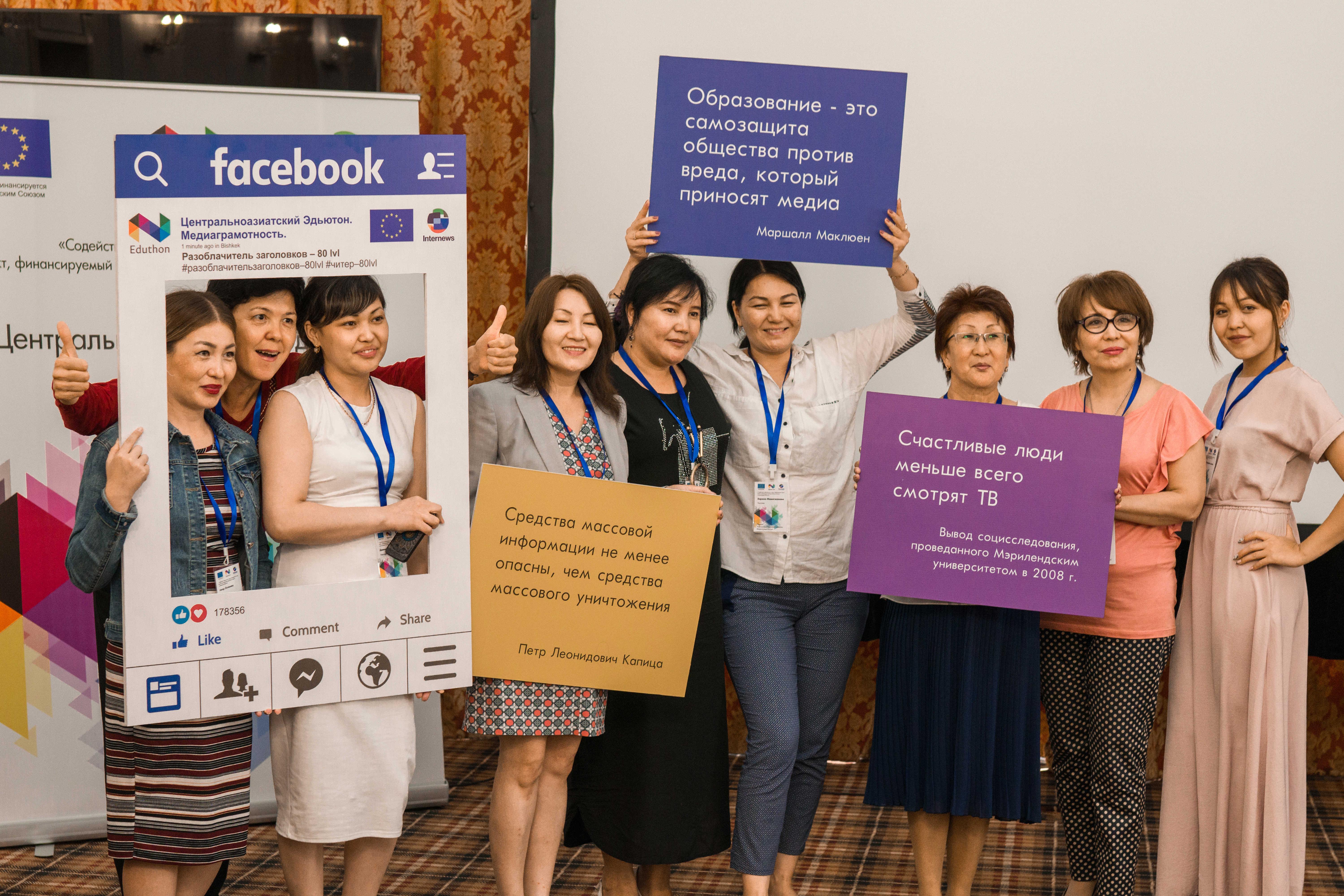 A group of women stand holding posters