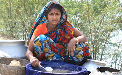 A woman sits by a container of water