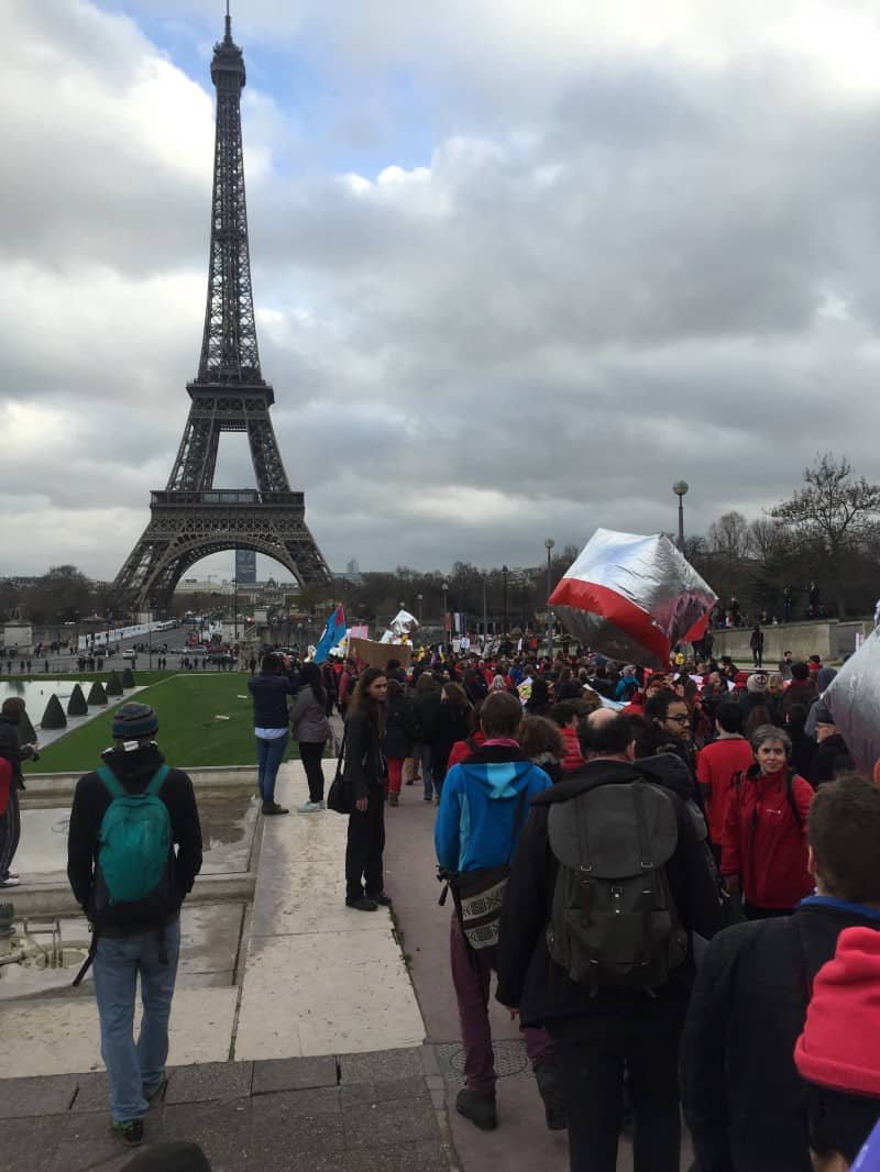 A crowd of people with the Eiffel Tower in the background.