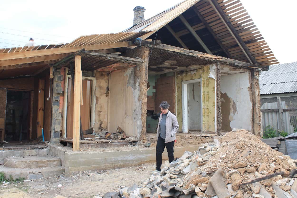 A woman walks by a building destroyed by an earthquake.