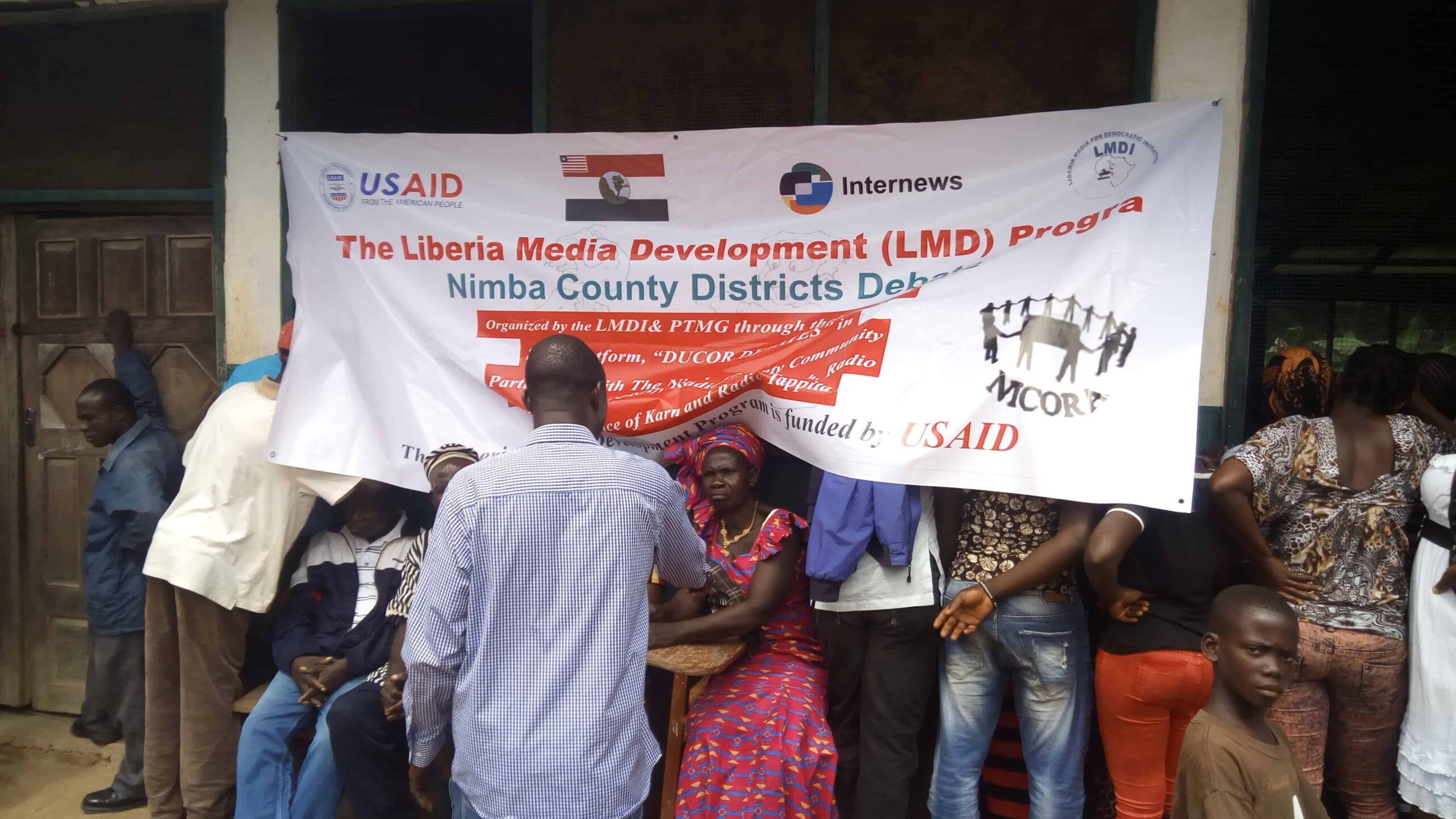 A group of people around a banner that says: The Liberia Media Development Program.