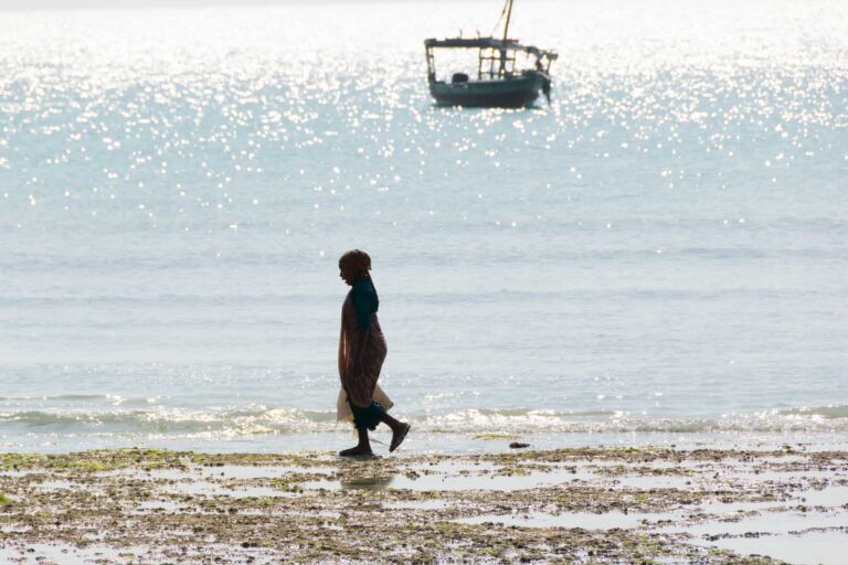 A woman walks on the beach.