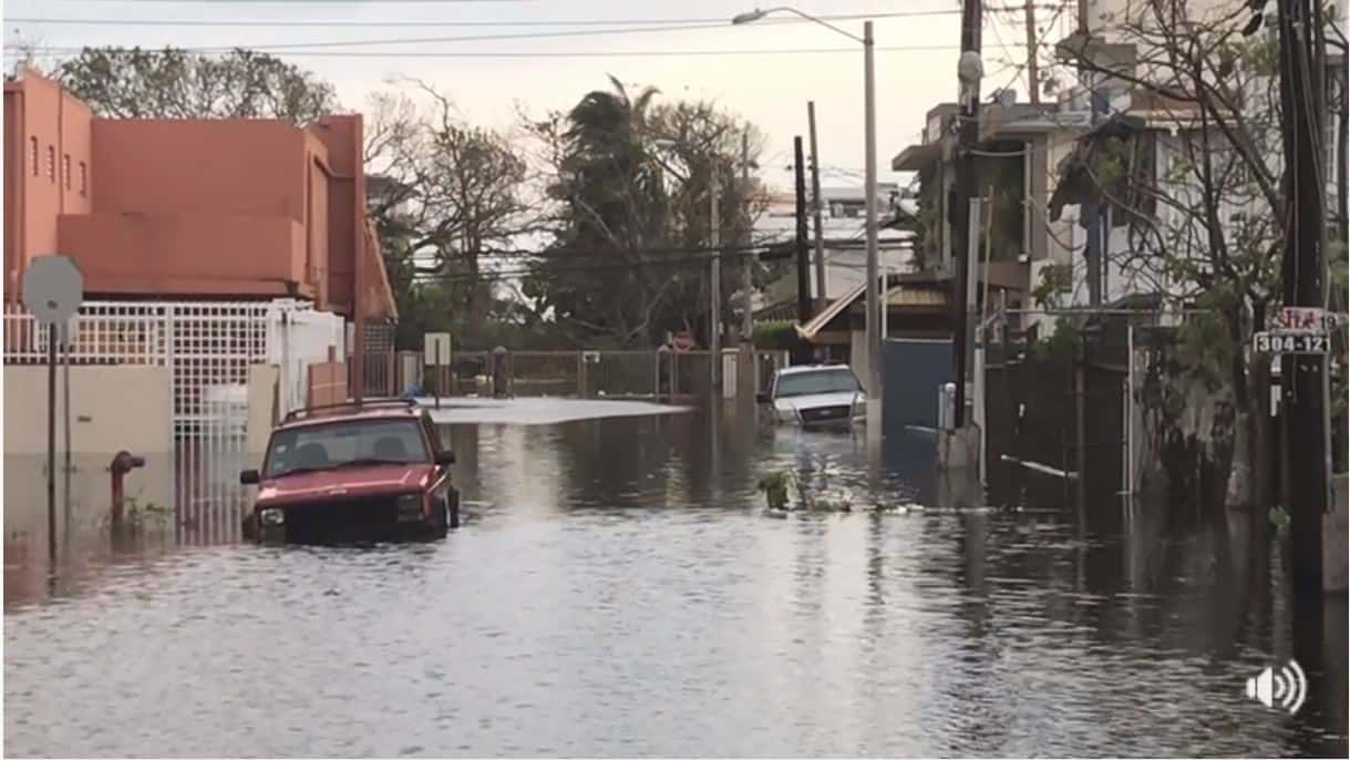 Two cars on a flooded street.