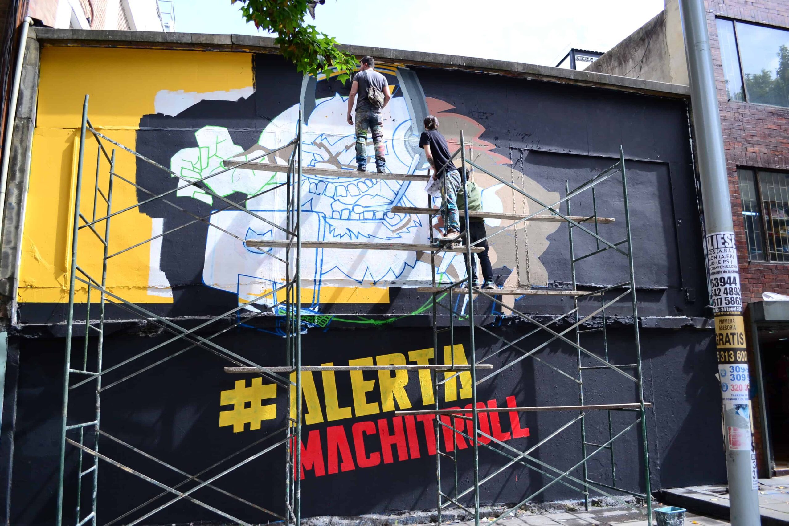 Painters paint a mural from a scaffold - #Alerta Machitroll