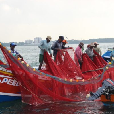 Men pull nets on to a fishing boat