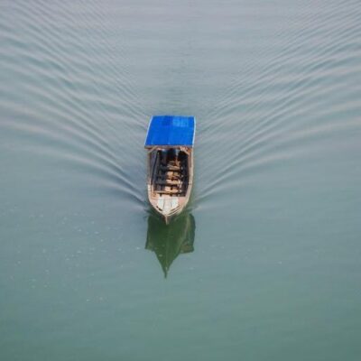 A small boat with a roof floats on the water.