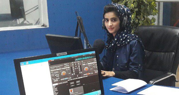 A woman sits in a radio studio