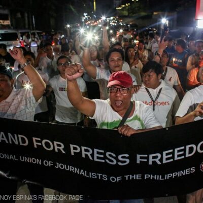 A protest with a banner reading "I stand for press freedom."