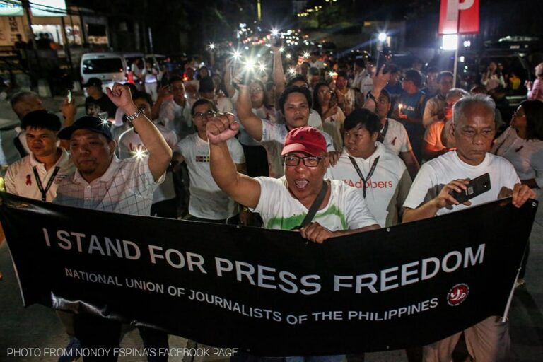 A protest with a banner reading "I stand for press freedom."
