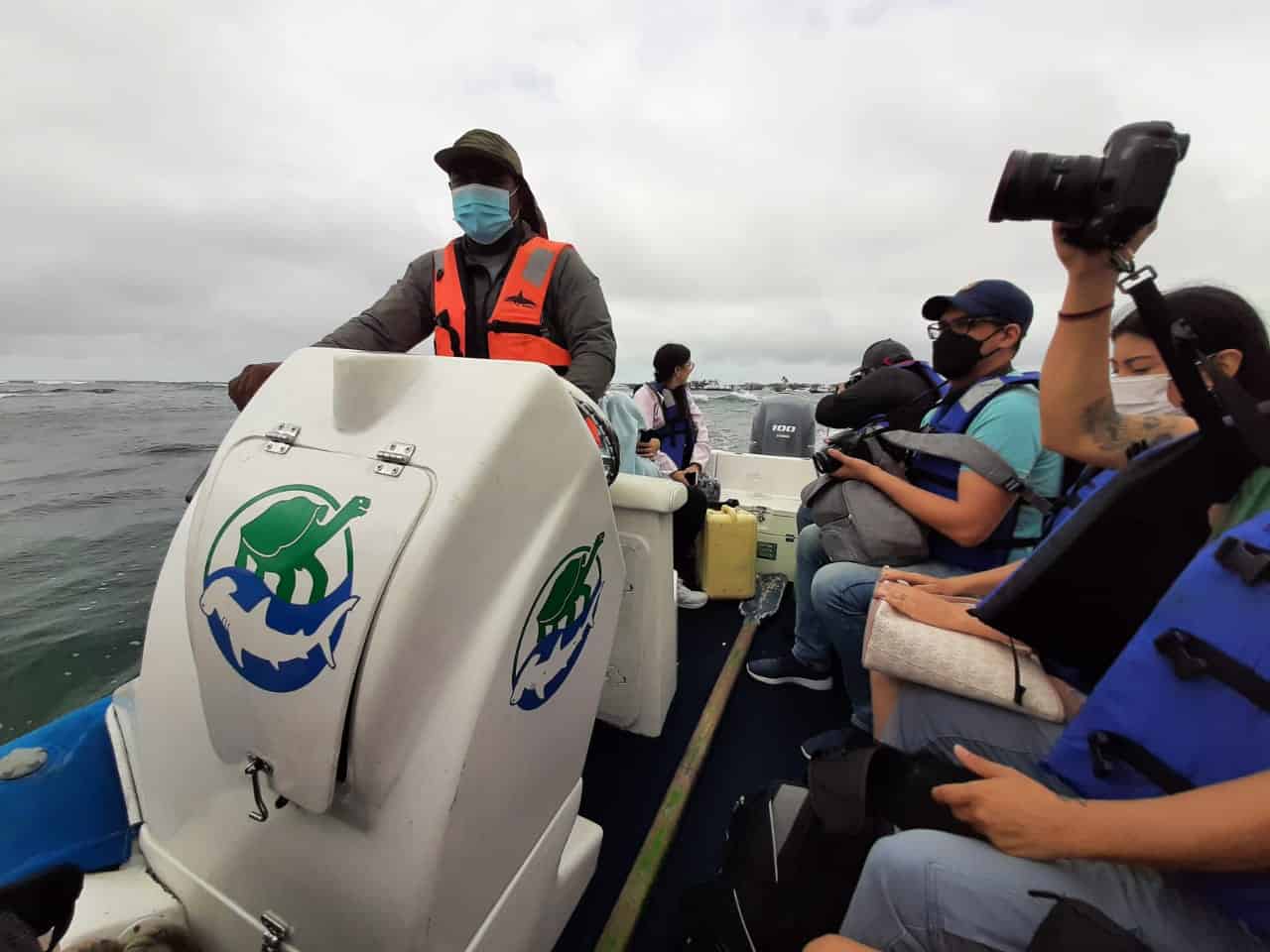 Journalists photograph on a boat.